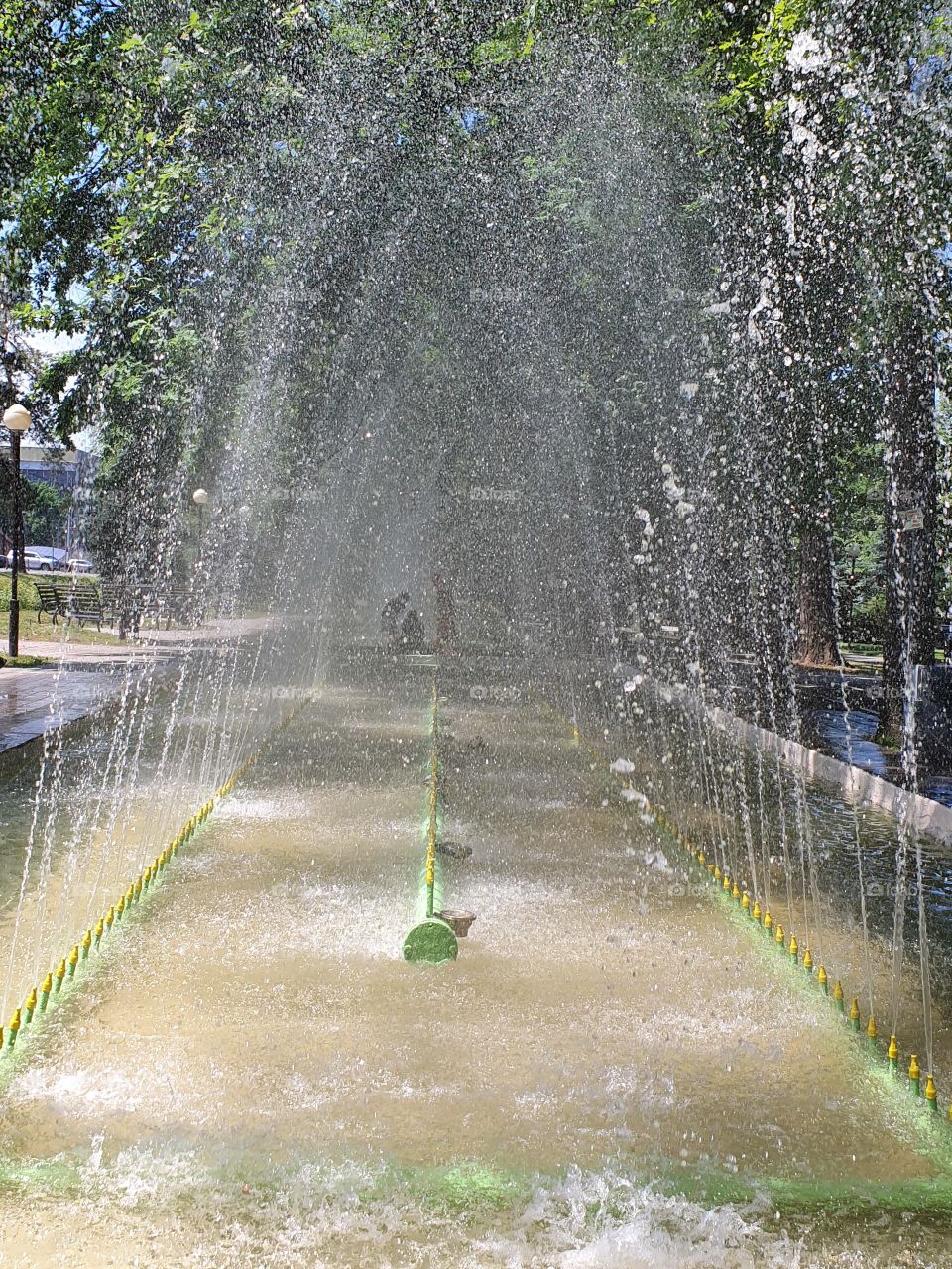 people silouetes behind fontain