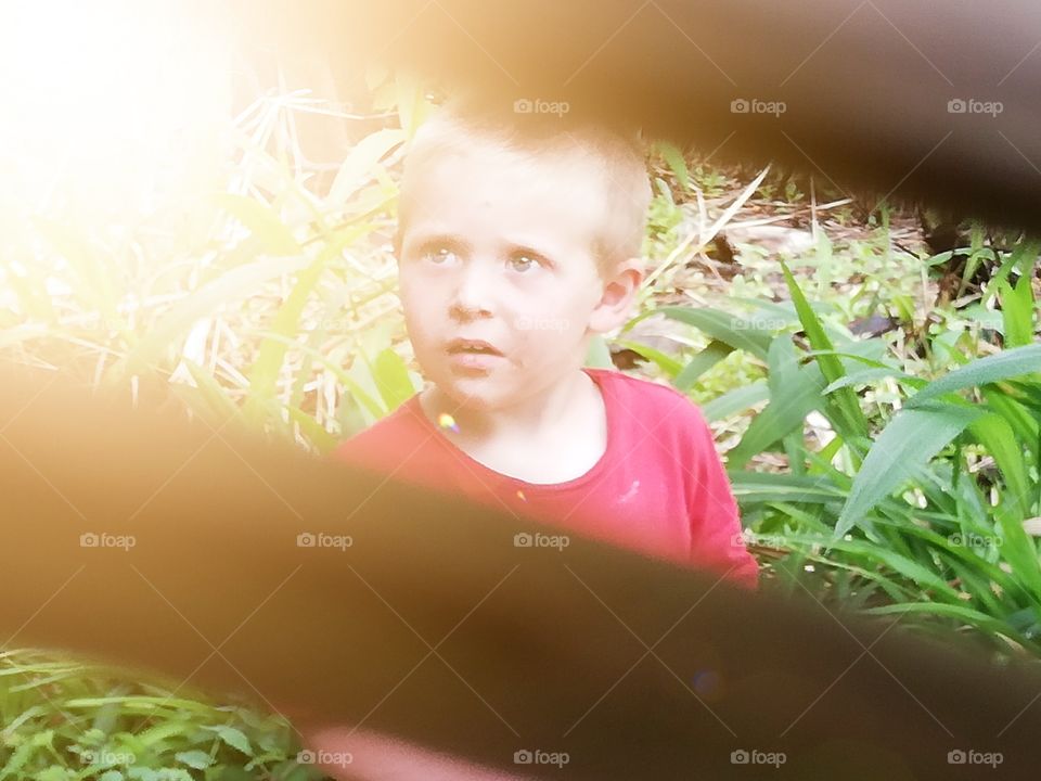 An child standing in the middle of a garden