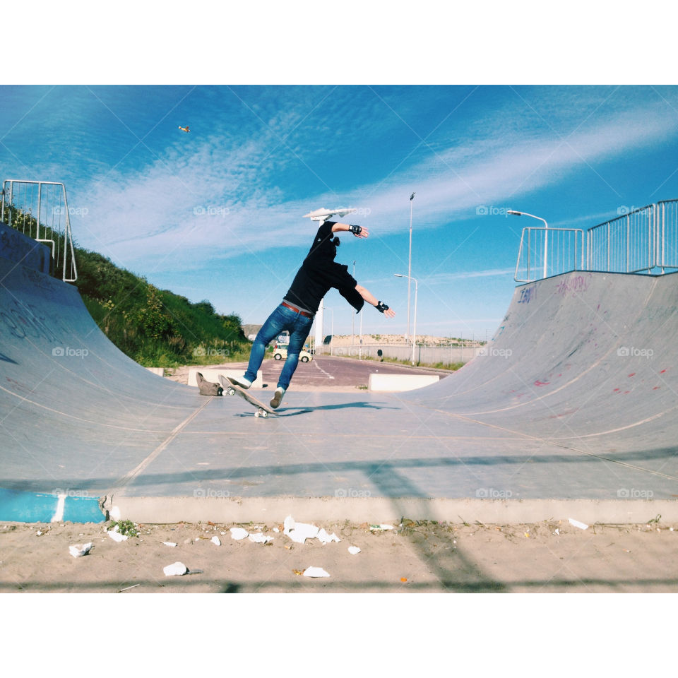 Uh oh trouble ahead! A guy wearing jeans and a black shirt on a skateboard who is about to fall.