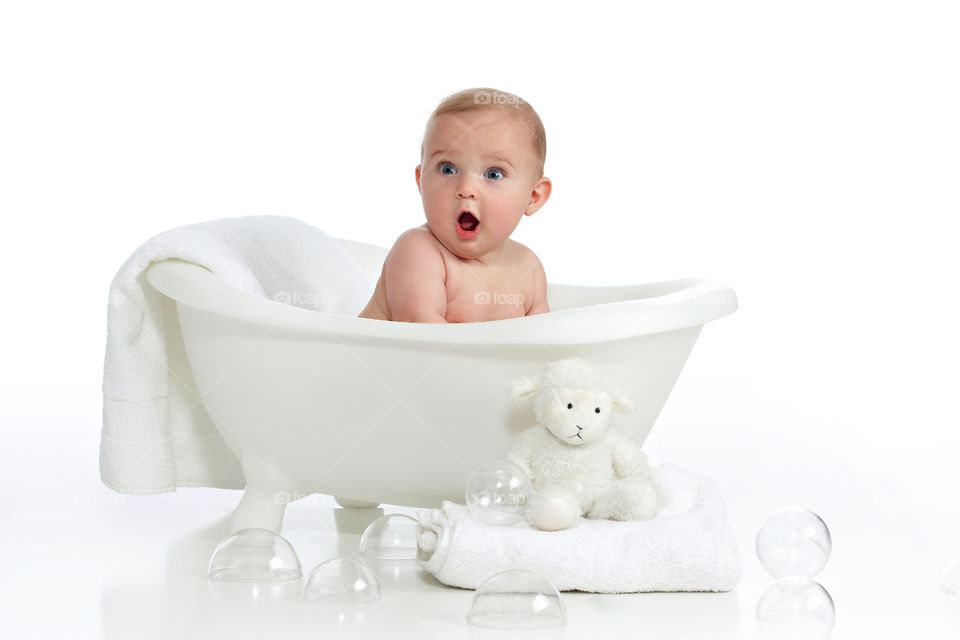 a surprised baby in a bathtub