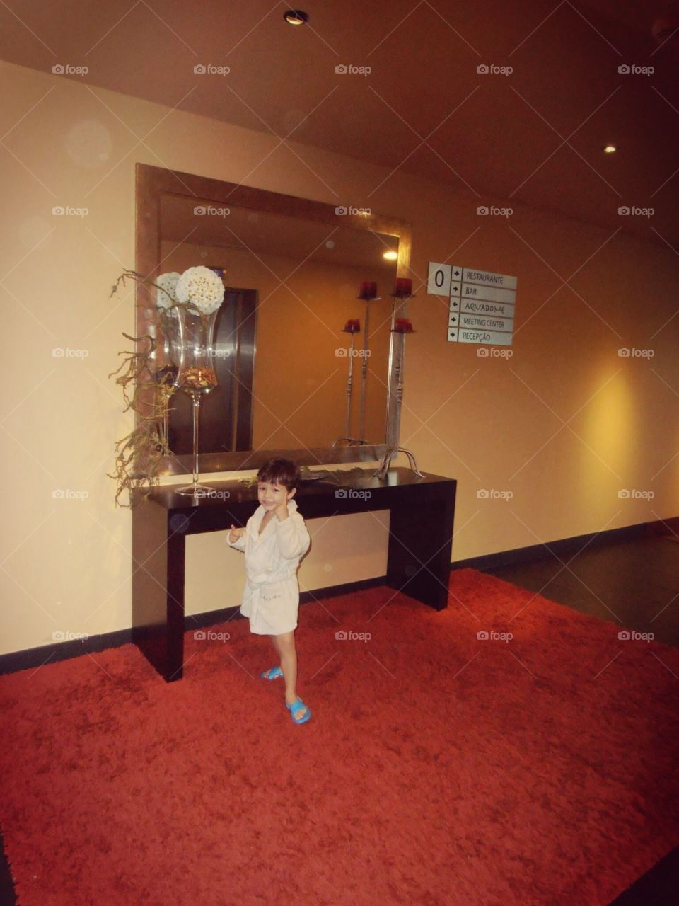 Criança de roupão a ir para piscina