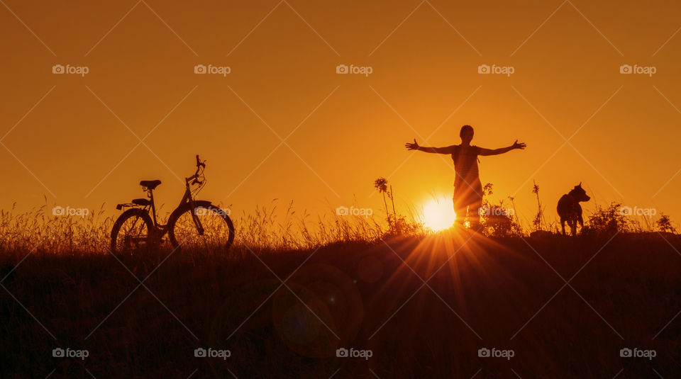 Silhouettes on hill at sunset