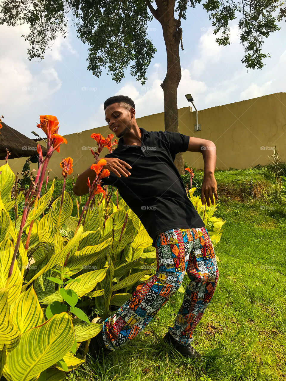 Man dancing in nature with flowers and blue sky 