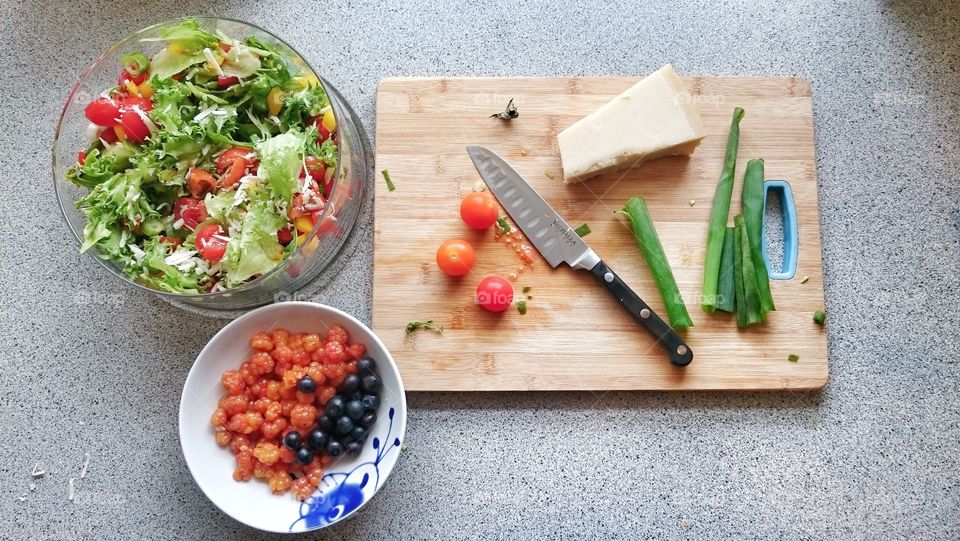 Vegetable salad with berries fruits on worktop