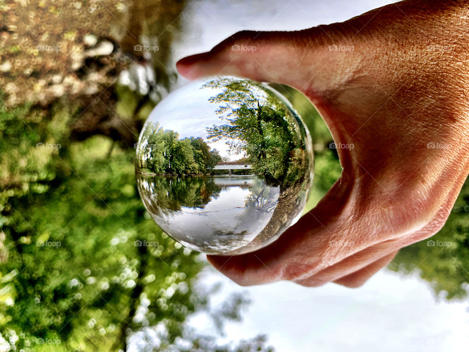 Covered bridge and the river through a lens ball