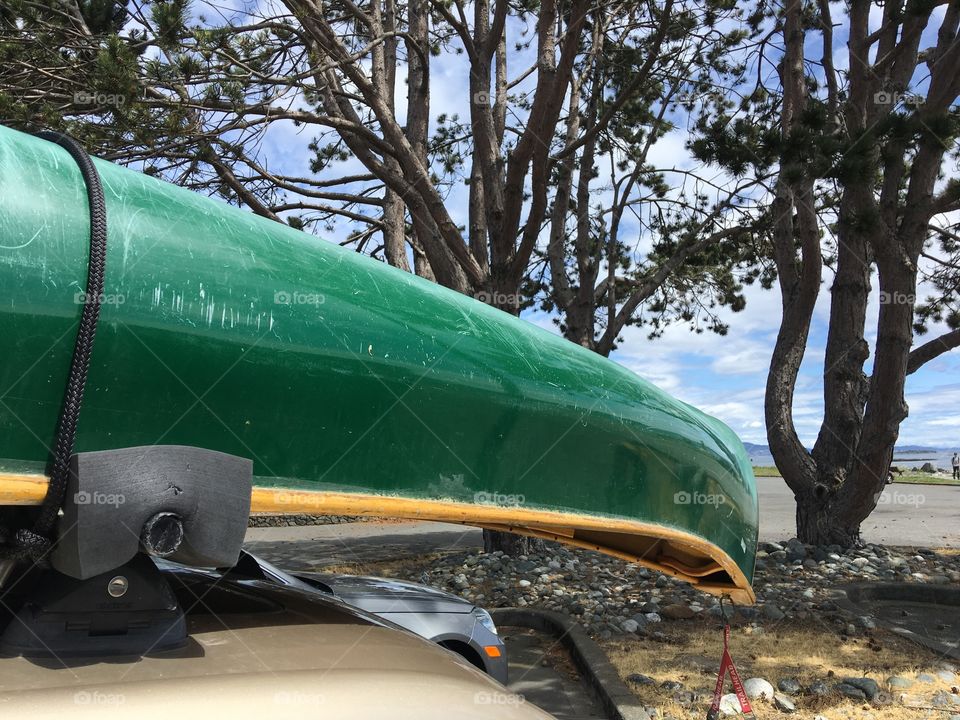 Green kayak on a rooftop of a car