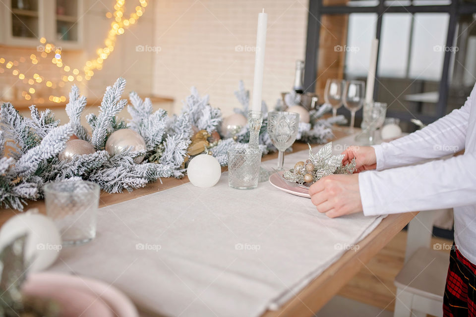 man sets a beautiful decorated winter table for a festive dinner.  Merry Christmas and Happy New Year.