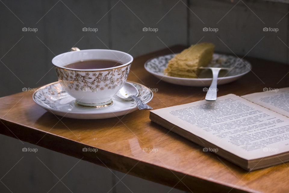 a cup of tea on the table and the book