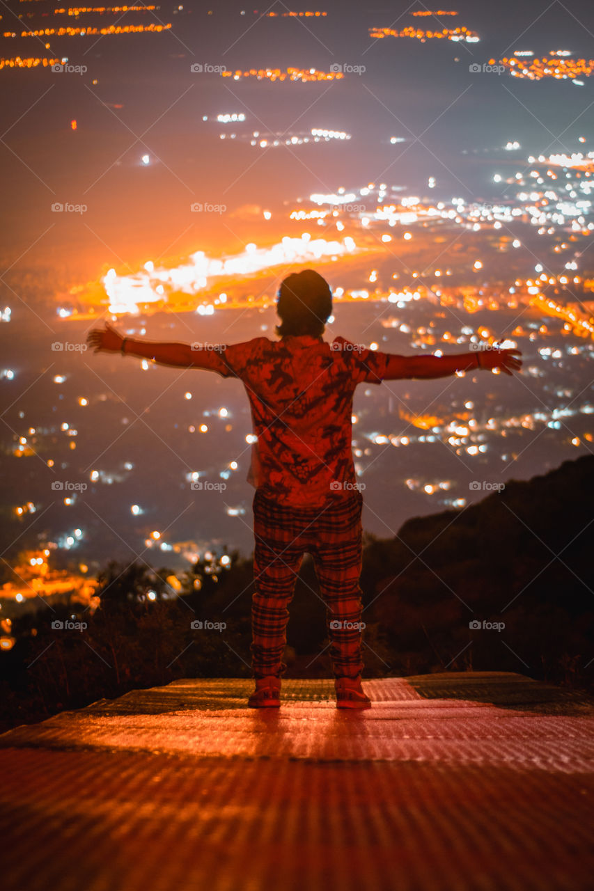 Man standing in front of the city at night.