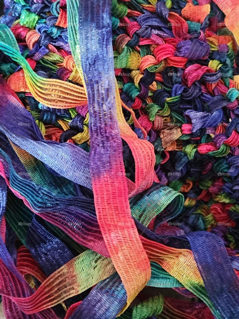 close up of bold rainbow colored ribbons attached to hand-made scarf