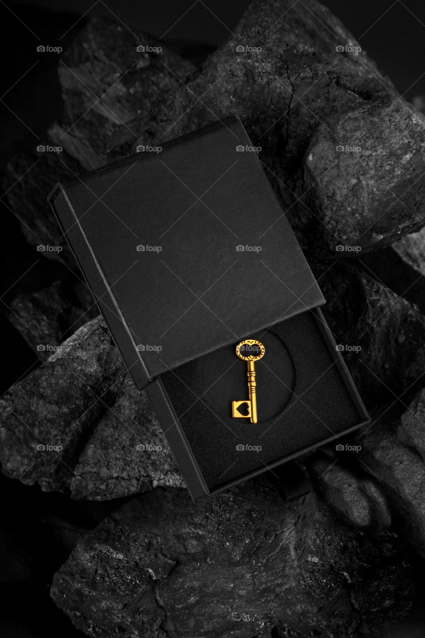 Antique golden key on a black box, success concept