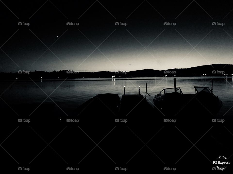 Monochrome landscape of lake night sky with moon boats and dock