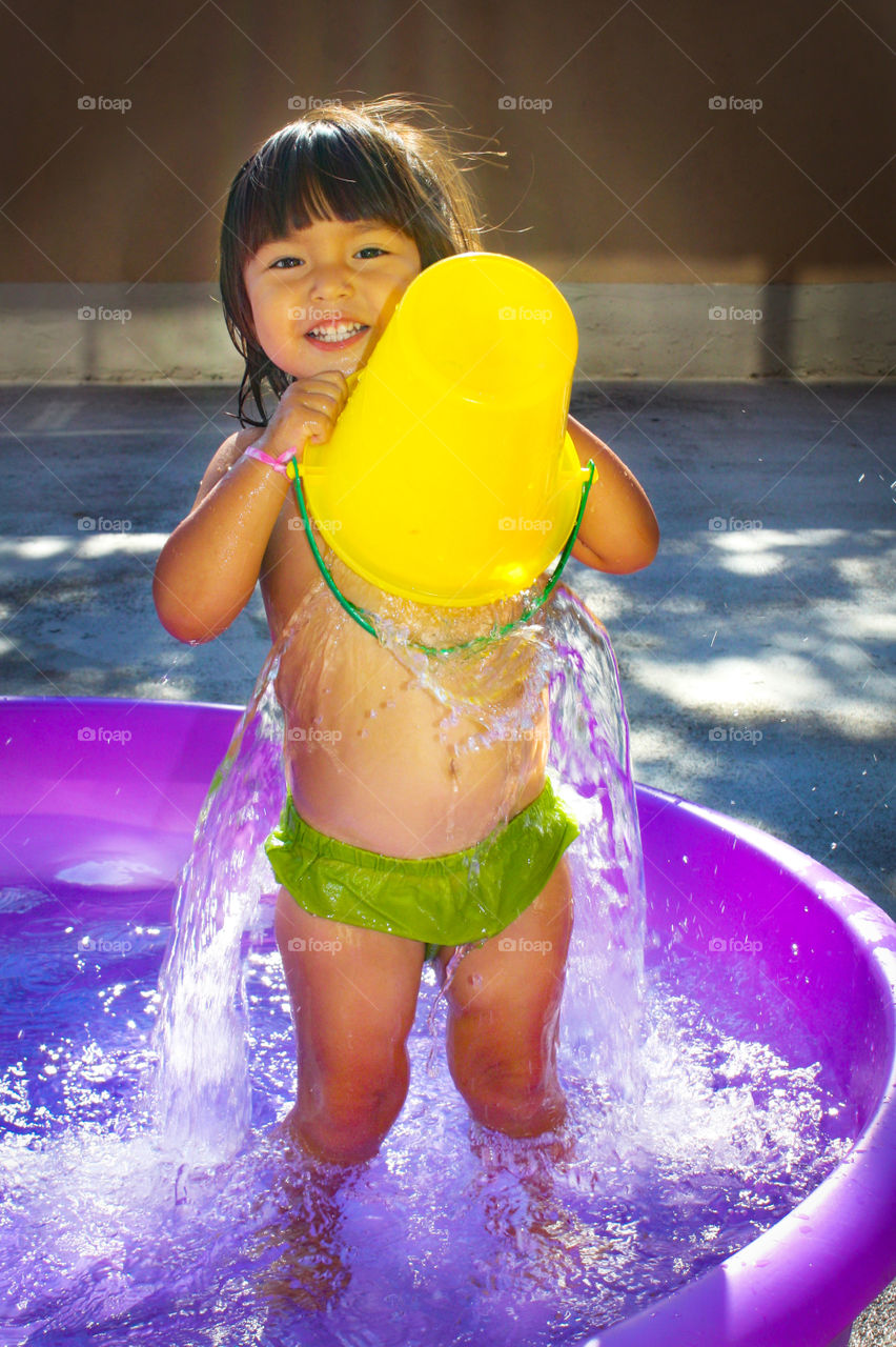 Cute girl is pouring water on herself