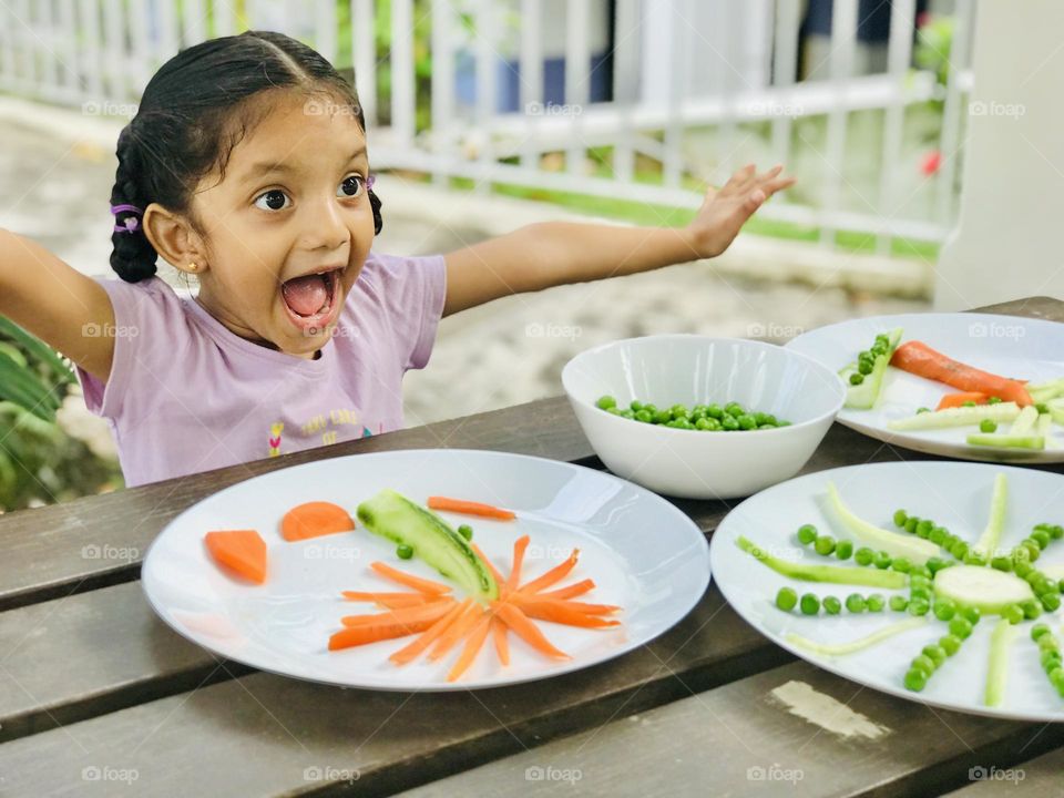 Girl feels so happy after finish her vegetables creative shapes task 