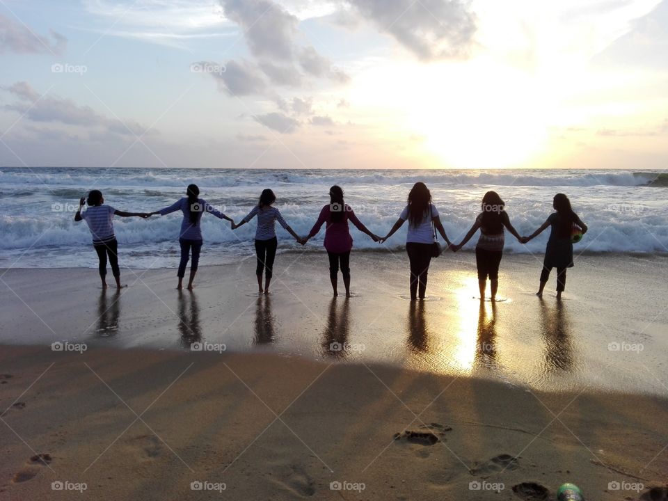 Girls holding hand at beach