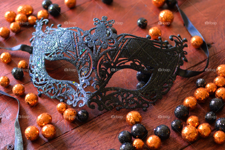 Black mask surrounded by orange and black balls