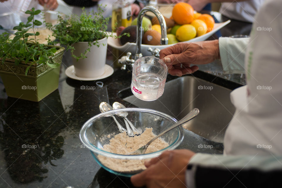 A woman is in the kitchen baking and cooking homemade scones with fruit and fresh herbs