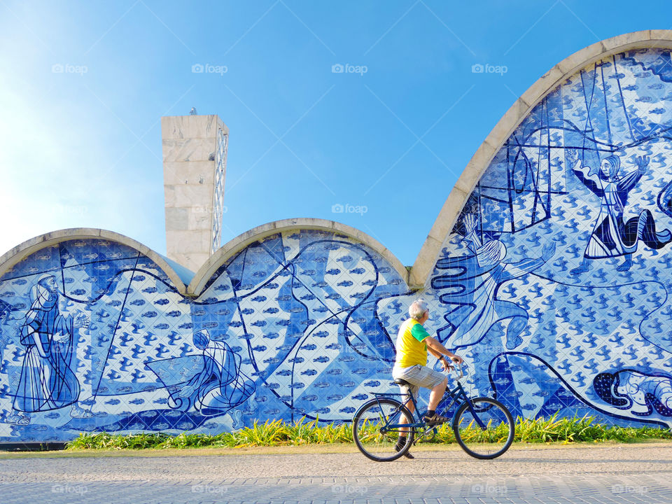 Man on bicycle looking at graffiti wall on street