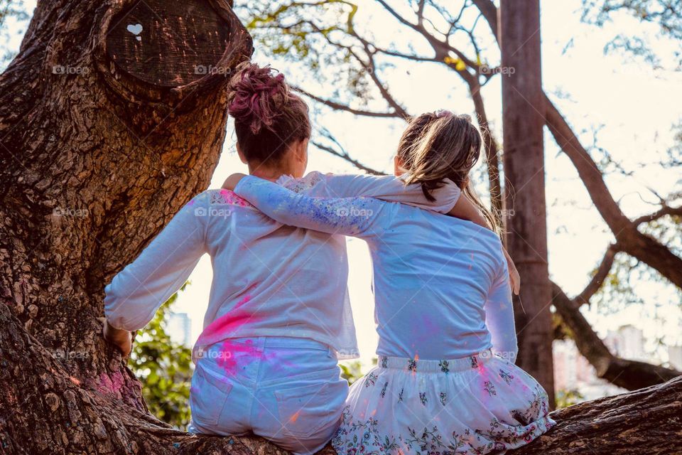 Friendship Moment - Two Girlfriends Embraced on Top of Tree