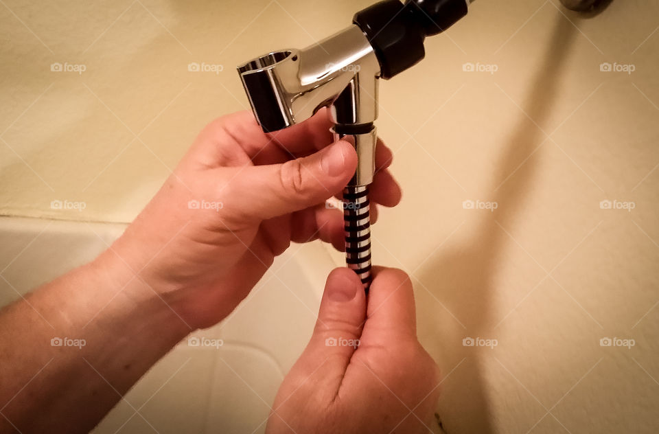 Close-up of plumber hand working on shower head