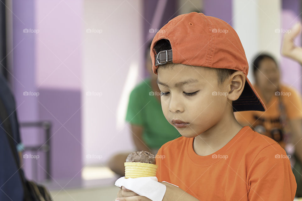 Asian boy holding the ice cream eating.