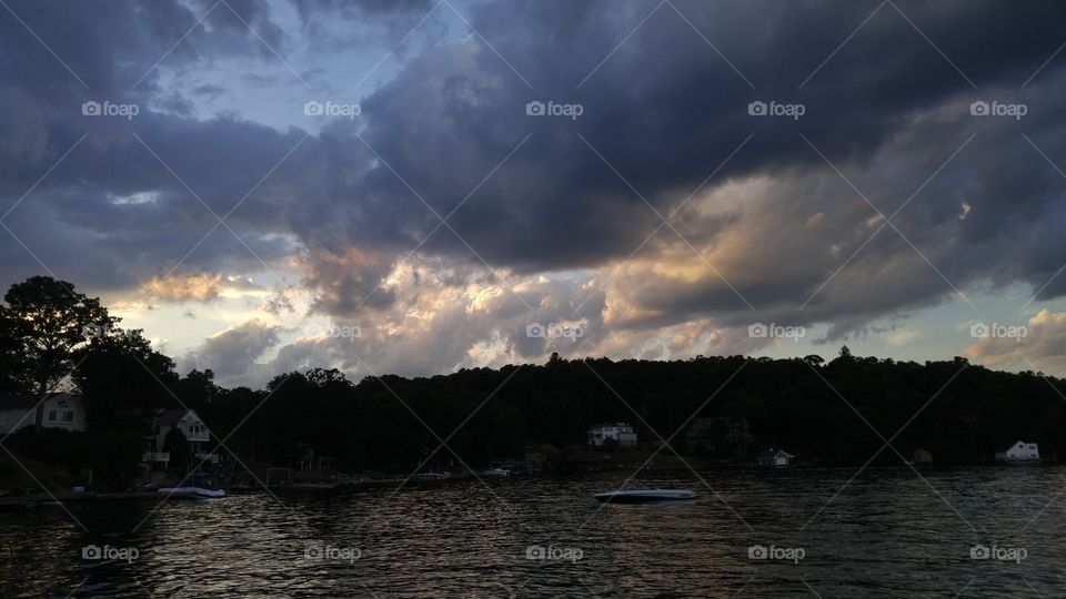 Silhouette of trees against storm clouds