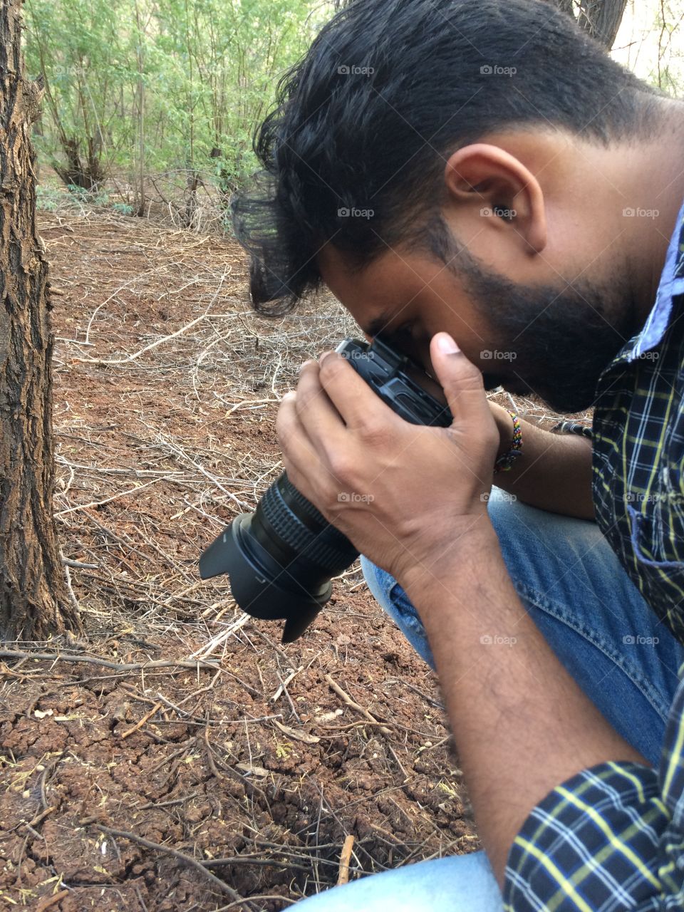 Side view of a man photographing ground