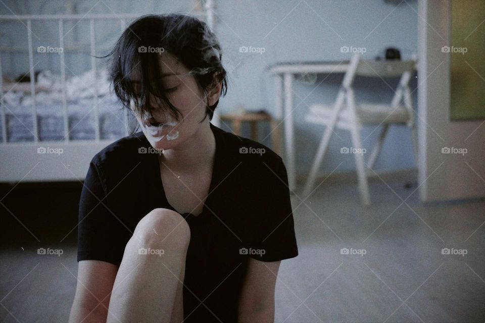 A girl with a short haircut blows smoke