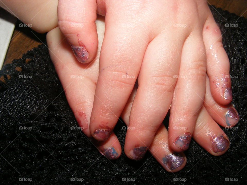 A little childs hands modelling freshly painted purple nail polish. A manicure just like mummy's.