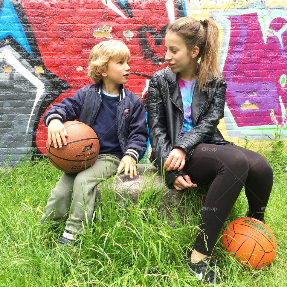 Kids and a basketball with graffiti wall