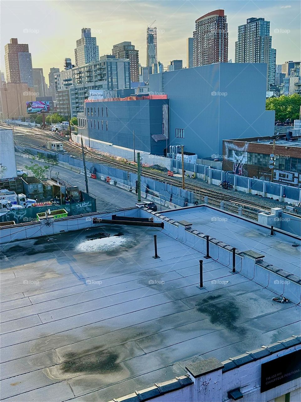 This is the view from the “Pulaski Bridge” at “Newtown Creek” in LIC overlooking the “Long Island Railroad” tracks and “iFly” in the rectangle building, an indoor flight simulator that mimics the free fall when parachuting. 2024. Hypnotic Productions