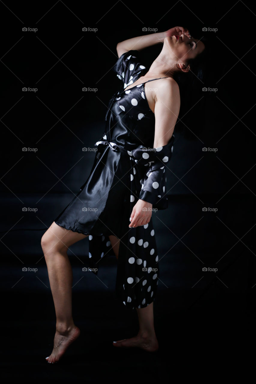 Woman in black looking sexy at black background, studio shot