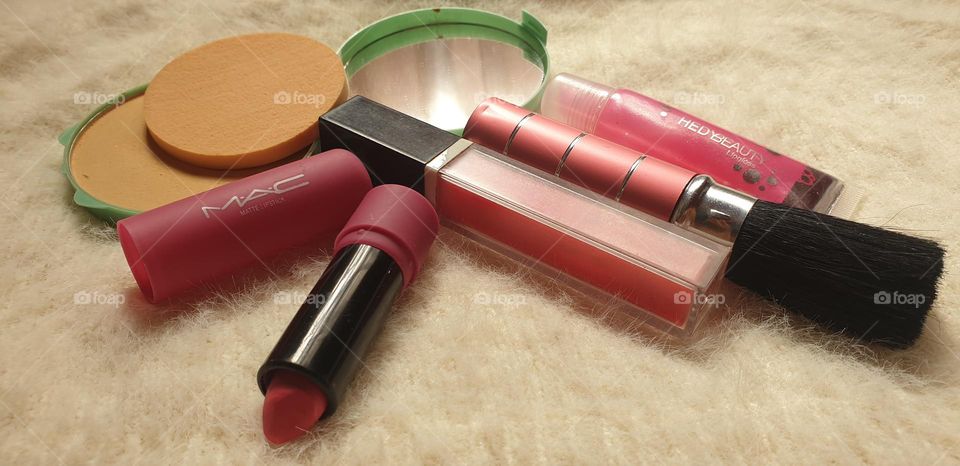 beautiful beauty accessories for ladies, lipstick, gloss, brush, and the mirror that cannot be missing.