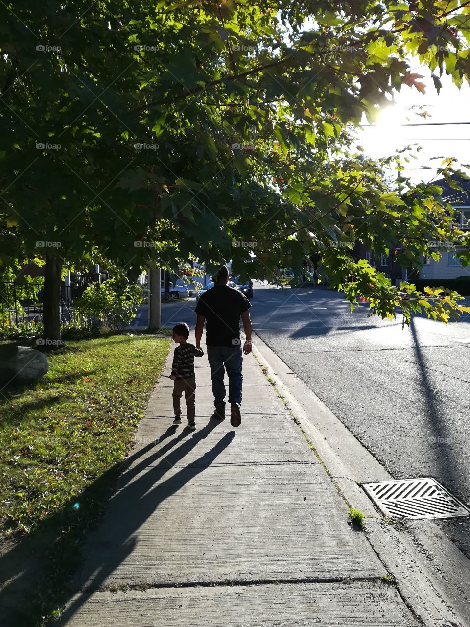 Father and son walking down sidewalk