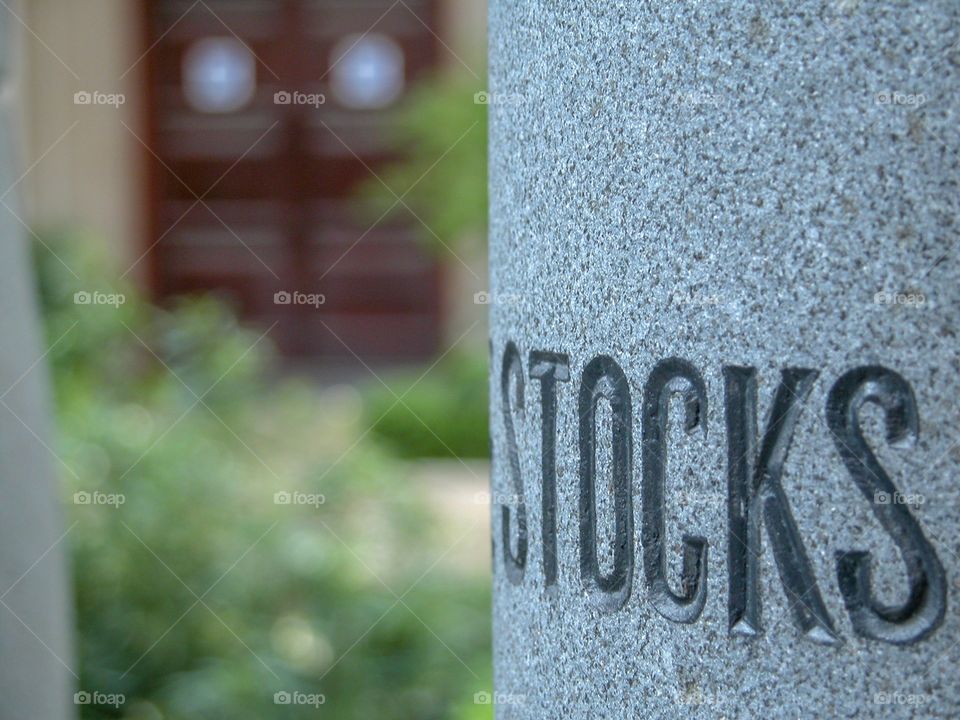 The word “STOCK” etched in granite