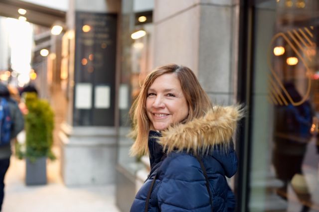 Woman walking down sidewalk in downtown Chicago looking back and smiling