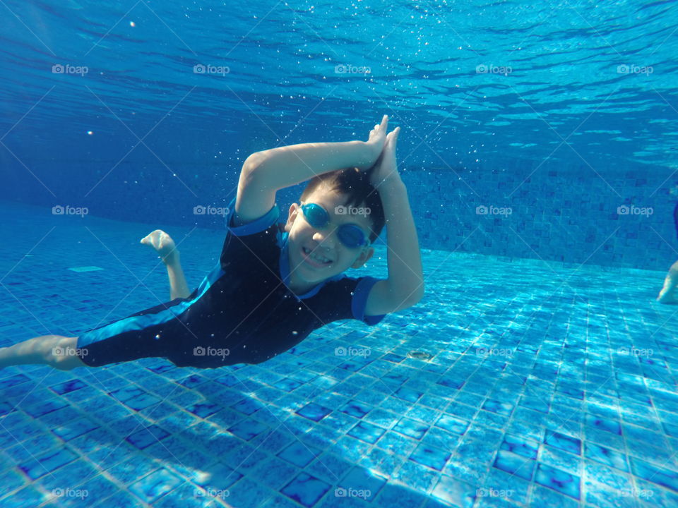 A little boy diving in a pool