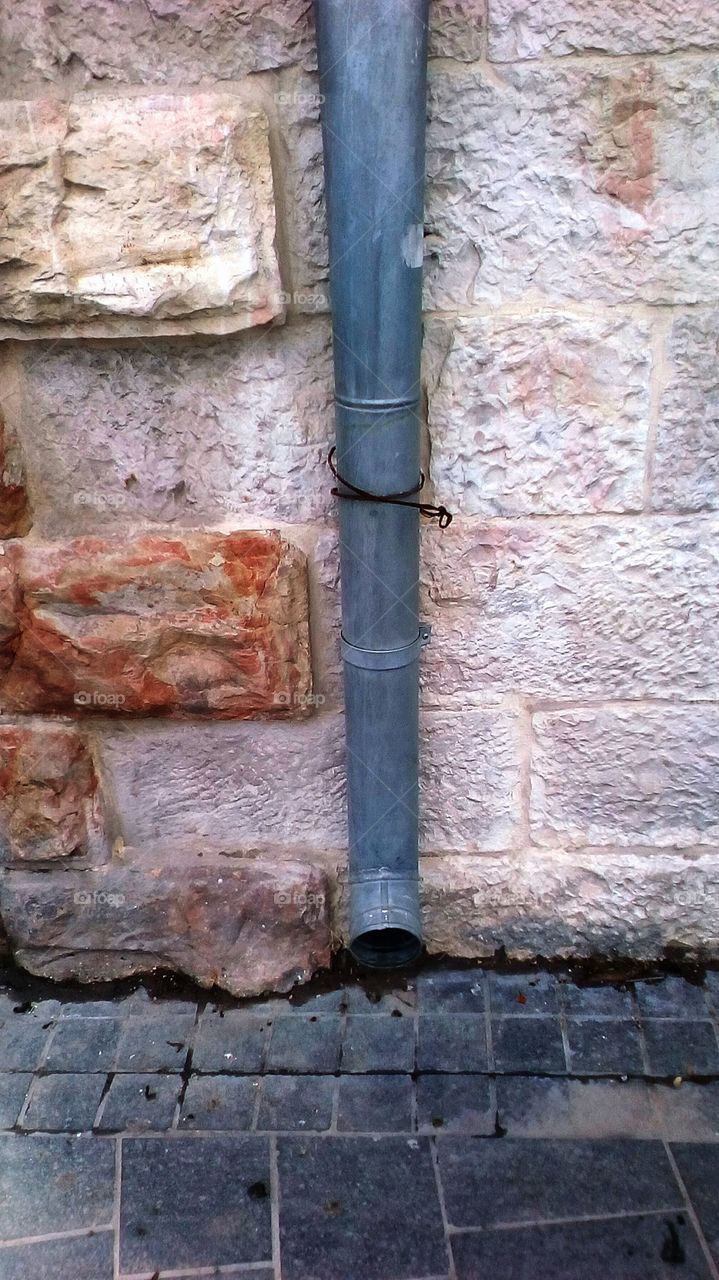 Ancient creative wall with old pipe water in street of Jerusalem