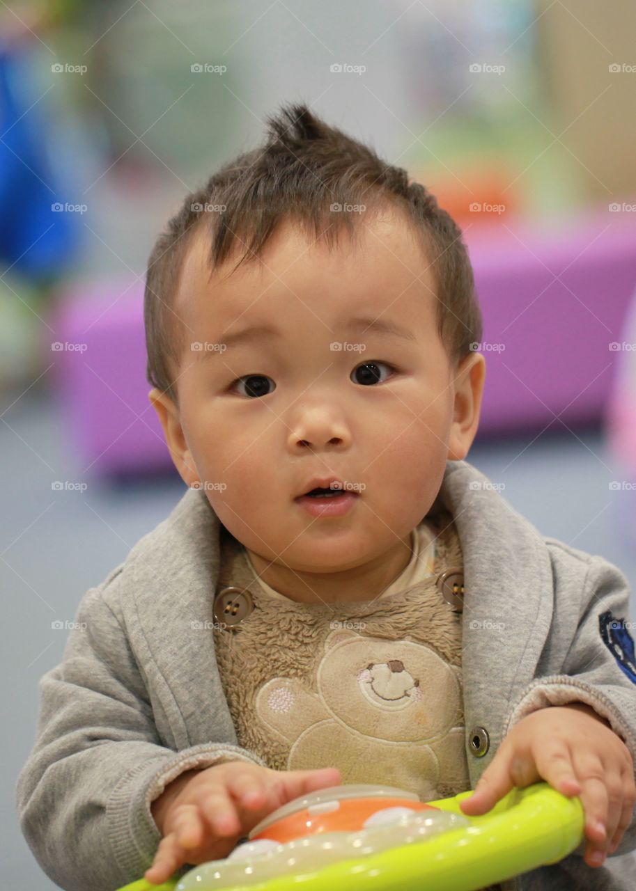 Cute Asian boy playing with toy
