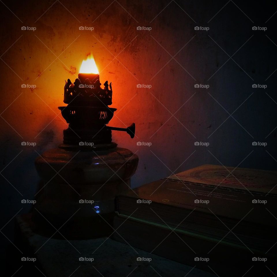 An oil lamp lit beside the book.