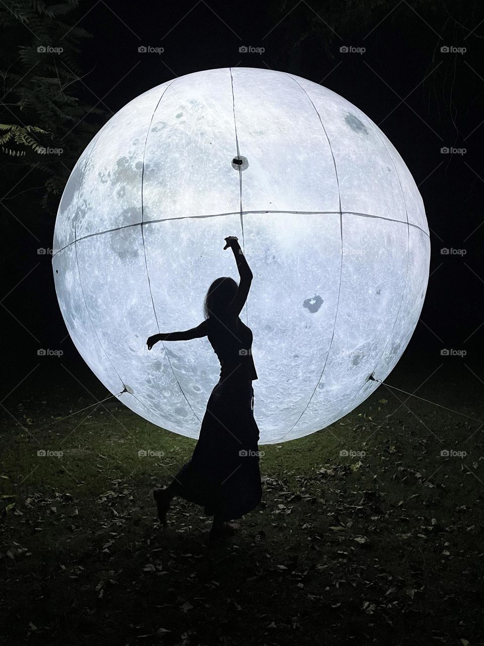 Woman Dancing in Front of the Art Installation Moon