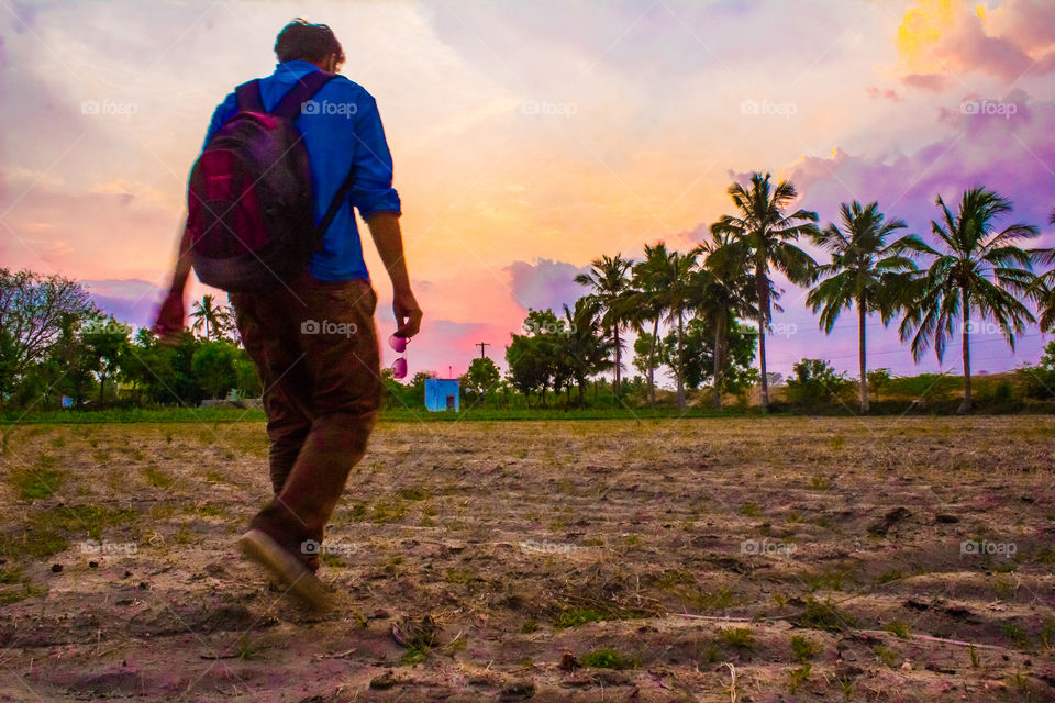 Rear view of a man walking during sunset