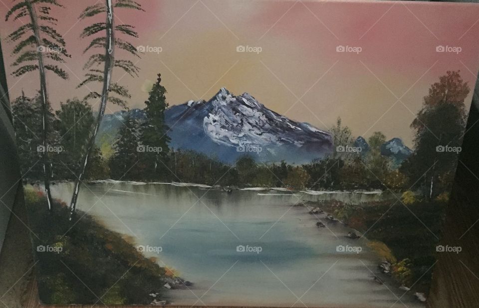 Oil painting of mountain water and light orange sky with trees red elected in the water. 