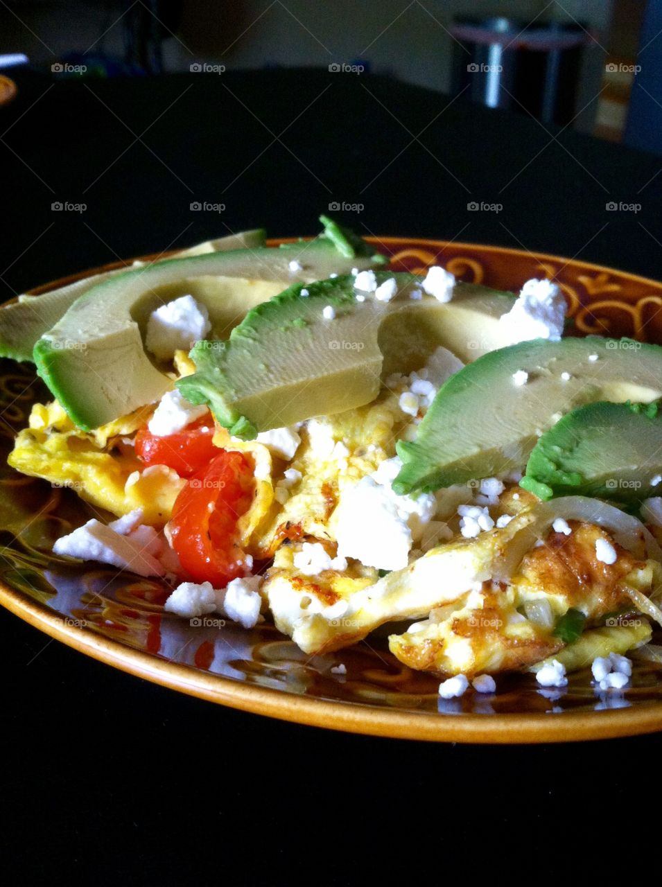 Healthy egg scramble with avocado, tomatoes and feta cheese