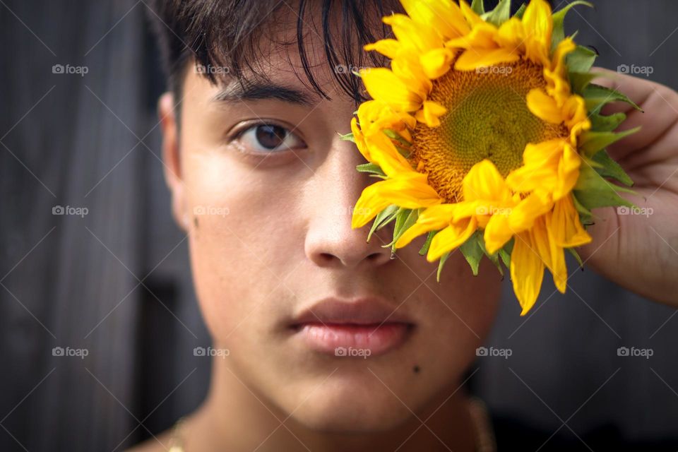 Handsome young man with a sunflower