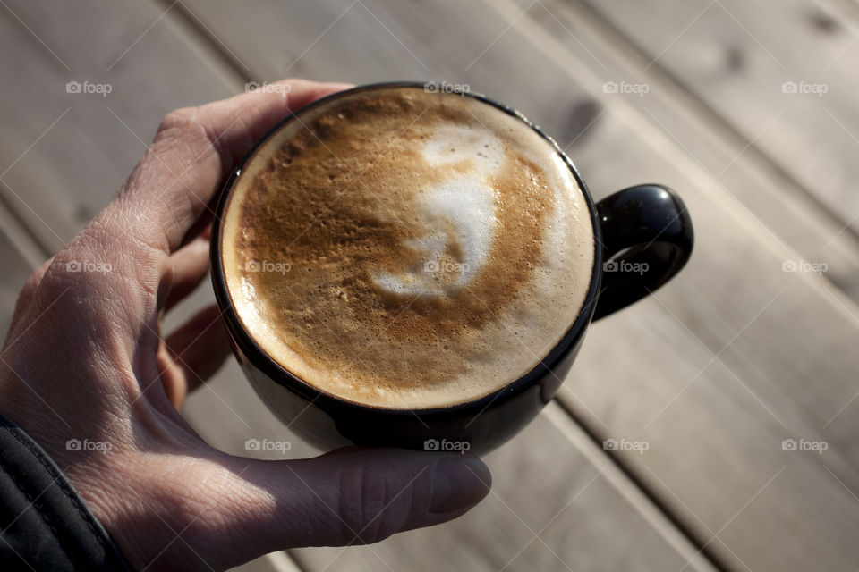 Human hand holding a coffee cup
