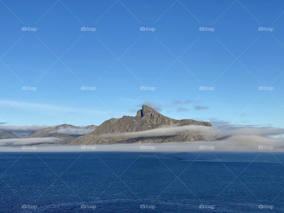 A mountain encircled by clouds