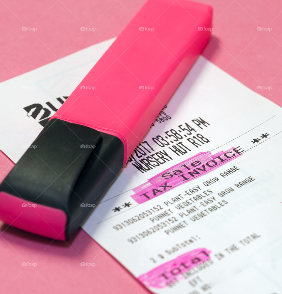 Pink highlighter  pen and docket with marked items.