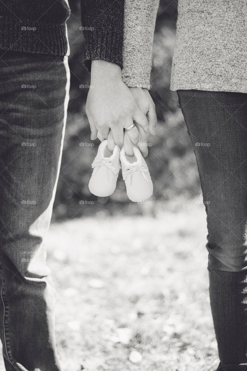 baby announcement photo with couple holding baby shoes