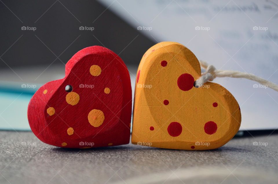 Multicolored wooden hearts near a greeting card